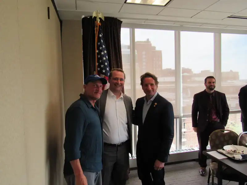 DJ Gries standing with Woody Harrelson and Dean Phillips